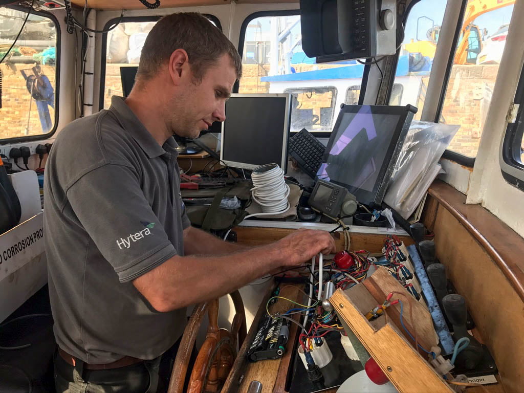 Luke working on a trawlers marine electronics system at whitstable